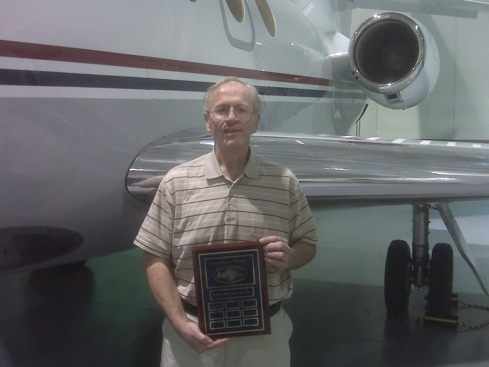Gary S. Goodpaster accepted the plaque from AMTSociety; he is standing in front of the left wing of one of The Kroger Company's Falcon 50's.