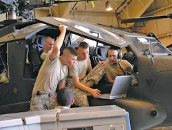 After soldiers master a task in virtual training, they use the portable computers to work on the real thing, here an AH-64 Apache helicopter. After soldiers master a task in virtual training, they use the portable computers to work on the real thing, here an AH-64 Apache helicopter.