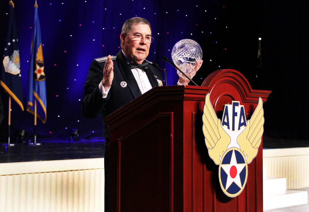 Brig. Gen. Larry Myrick holds the Air Force Association's 2014 Lifetime Achievement Award, which he accepted on CAP's behalf, as he addresses those gathered during the AFA's Air & Space Conference in National Harbor, Md.