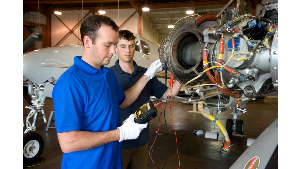Vector technicians work on aircraft engine