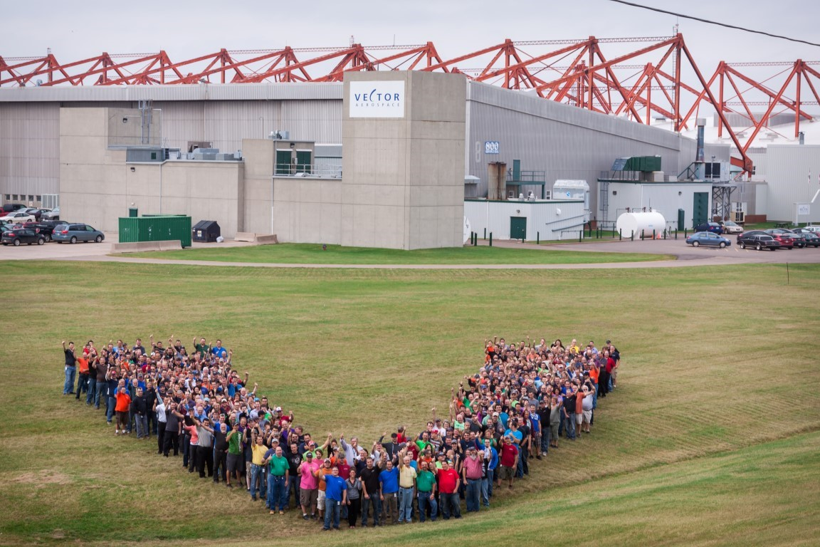 Vector employees in a V formation outside the Summerside facility.