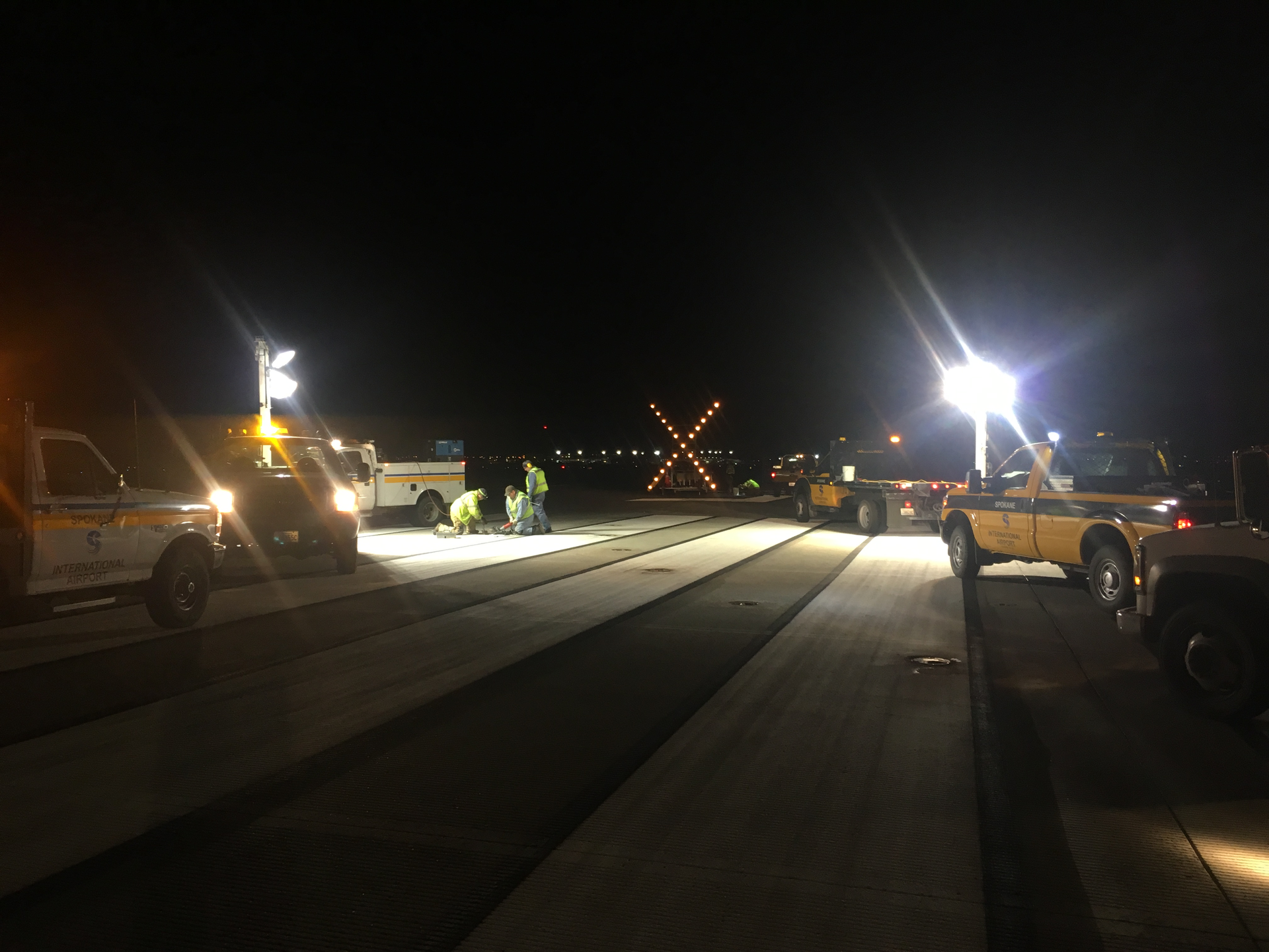Airfield Maintenance employees working on an in-pavement flush mounted runway touchdown zone light.