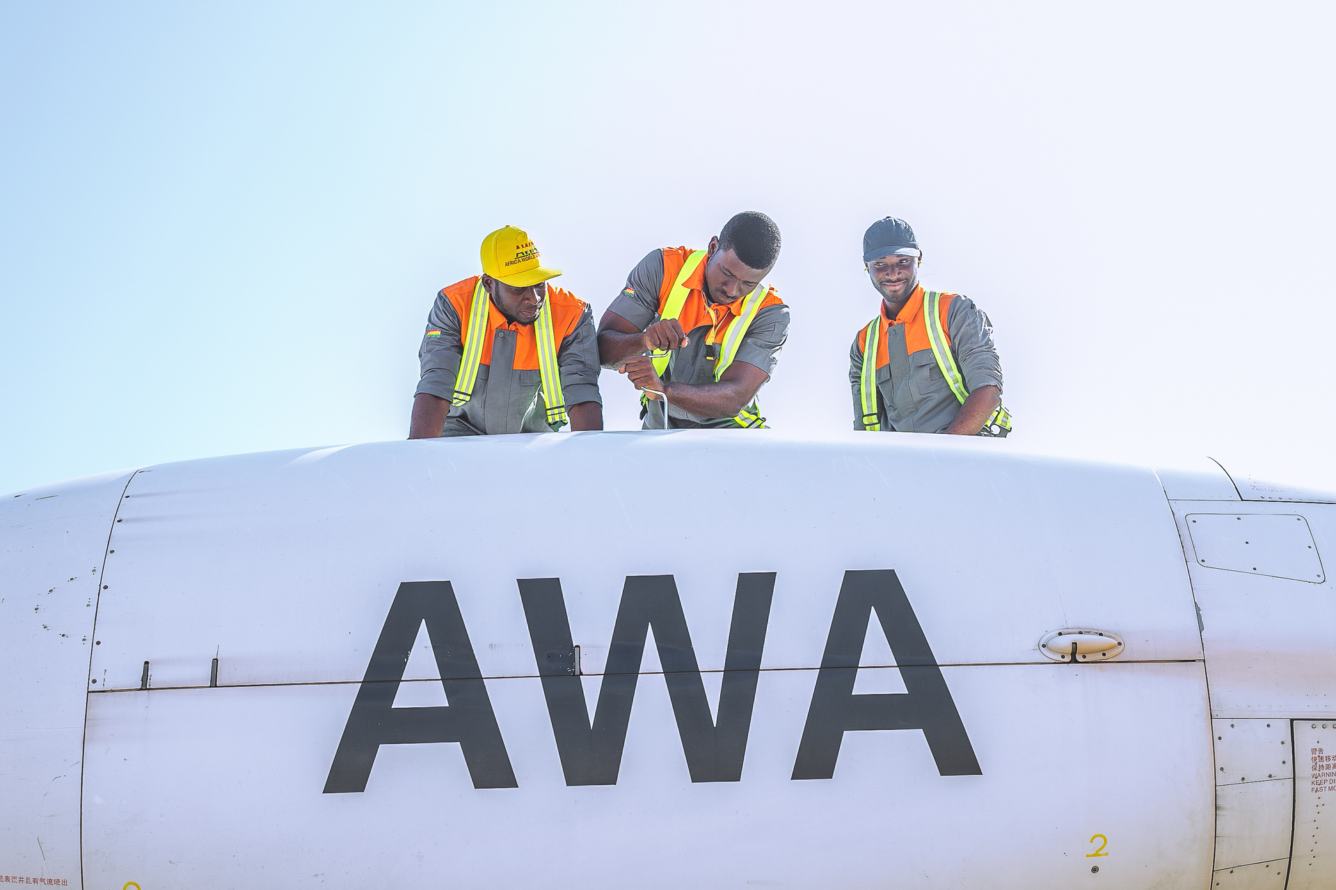 Africa World Airways technicians finishing a maintenance task on left engine.