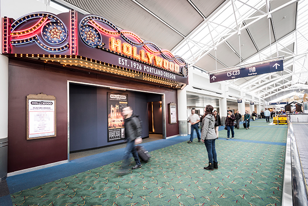 A PDX passenger stops to admire the Hollywood Theatre's marquee.