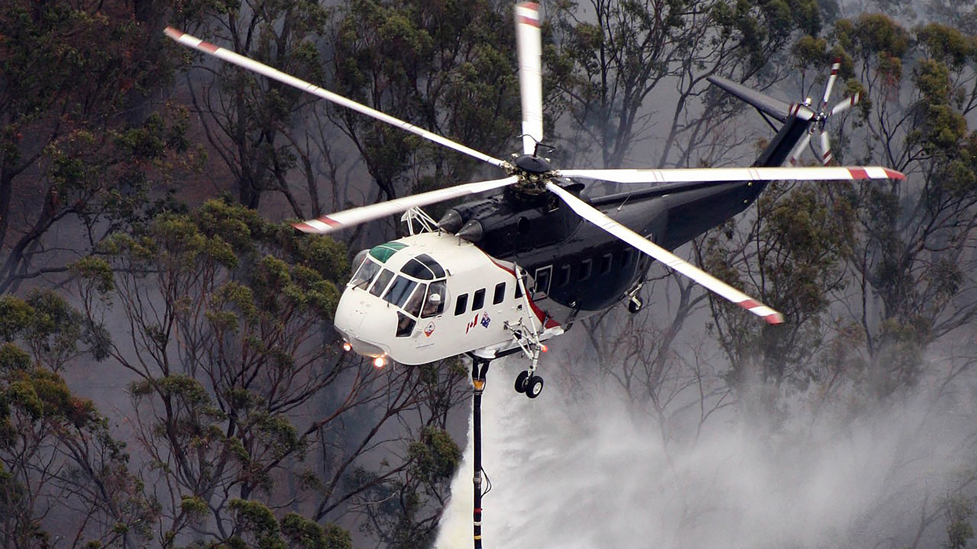 A Sikorsky S 61 Helicopter Performs A Water Drop During An Aerial Firefighting Mission