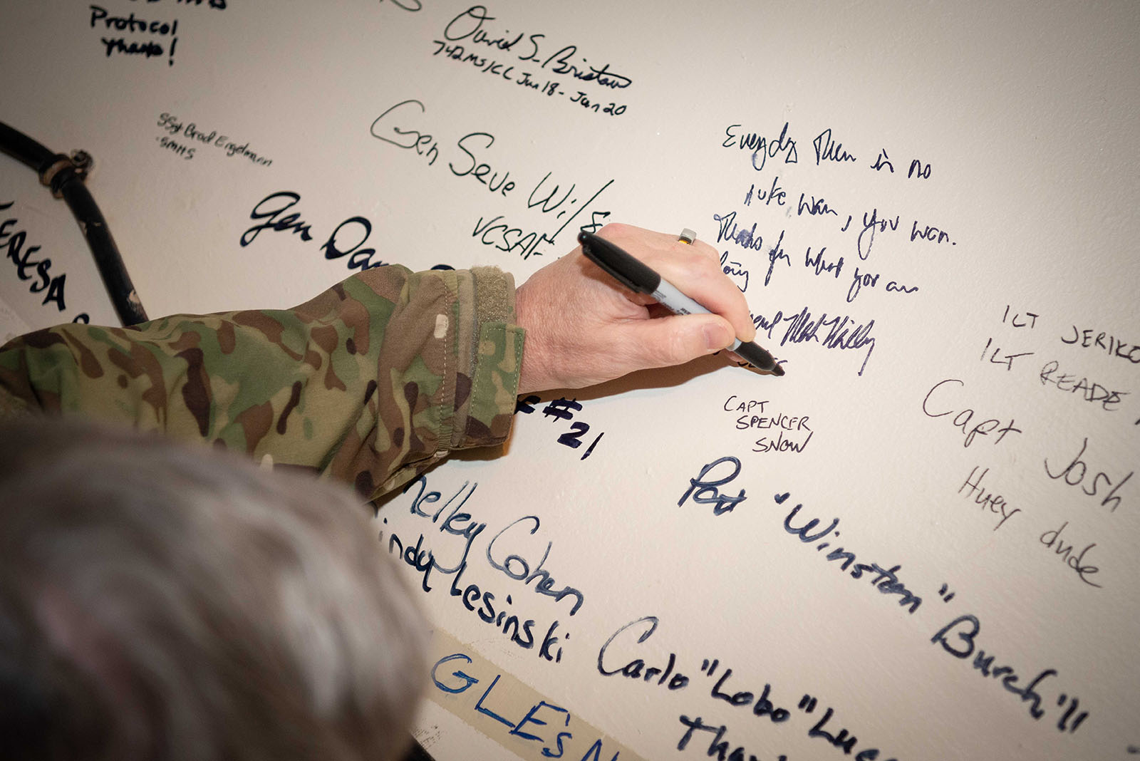 Army Gen. Mark A. Milley, chairman of the Joint Chiefs of Staff, signs a wall after writing 'every day there is no nuke war, you won. Thanks for what you are doing,' during a tour of Minot Air Force Base, N.D., March 26, 2021.