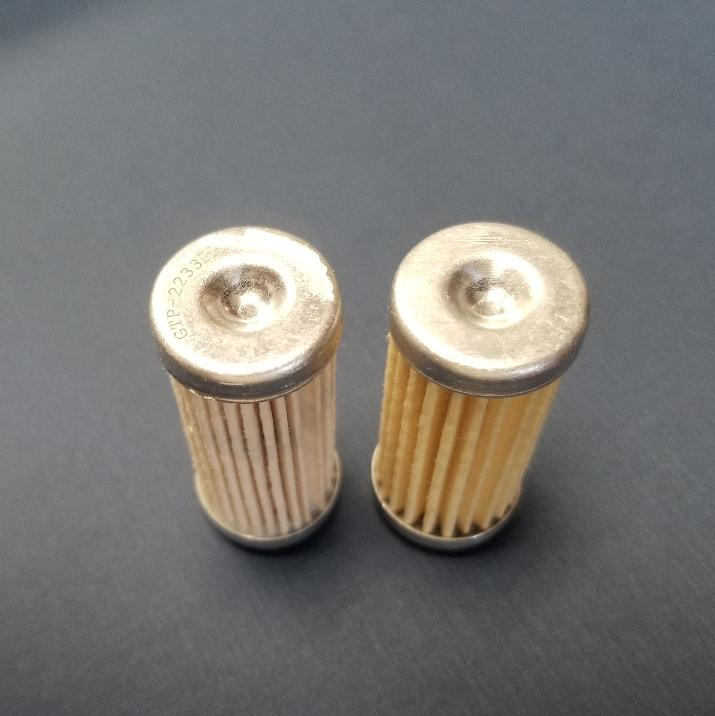 On the left is Gammon's filter, with part number GTP-2233 etched into the end. The other is a not-equal, but similar-looking filter, made for a different hydraulic application. The authentic part on the left has more pleats. In addition, the seal material of the part on the right is not compatible with all aviation fuels and the size of the seal is too large to properly seal in Gammon's gauge.