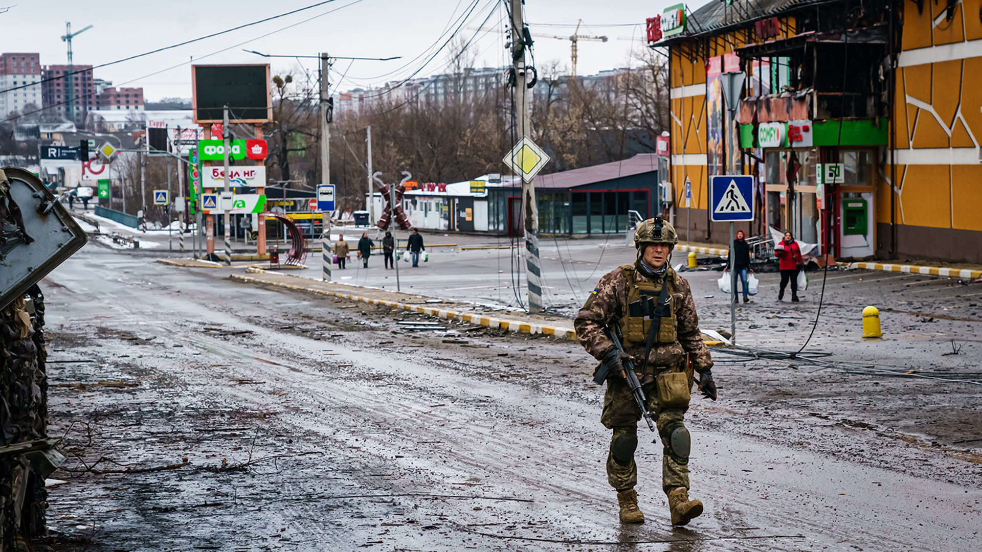 A Ukrainian soldier walks past a building that was destroyed in the midst of battle with the Russians, on the outskirts of Irpin, Ukraine, Tuesday, March 1, 2022.