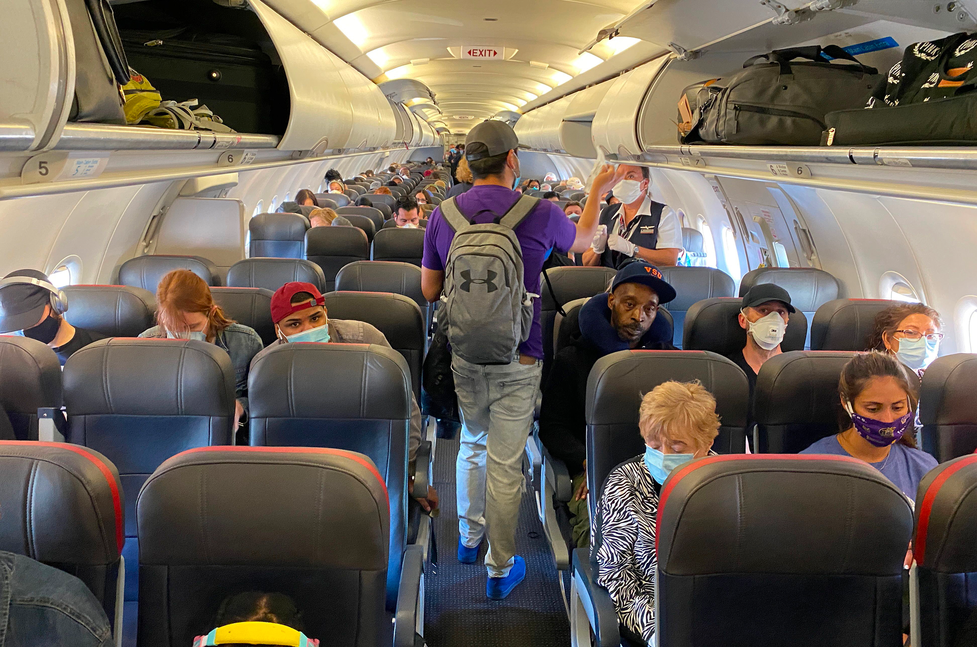 Passengers, almost all wearing facemasks, board an American Airlines flight to Charlotte, North Carolina, on May 3, 2020, in New York City.