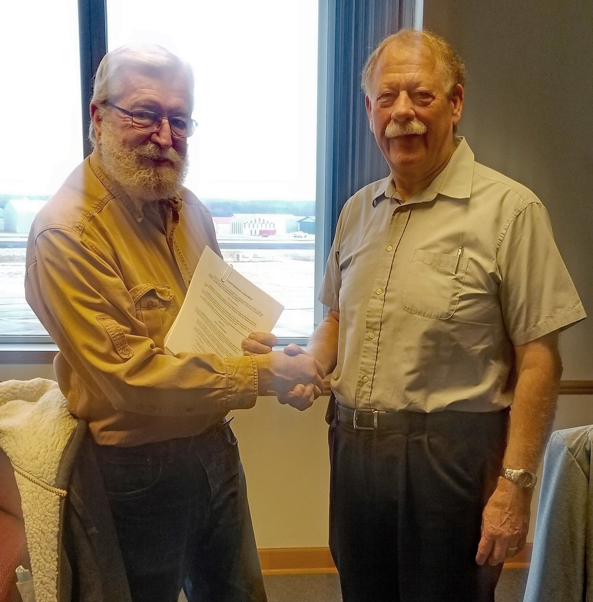 Beaver Aviation President and Owner Charles Swain and Wisconsin Aviation President and CEO Jeff Baum shake hands after the acquisition closing.