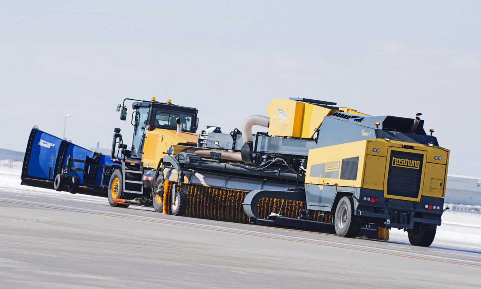 ATI&rsquo;s Snow Mauler as tow truck with mounted snow plow and Boschung&rsquo;s high performance sweeper blower hanger unit the Jetbroom 10000 T.
