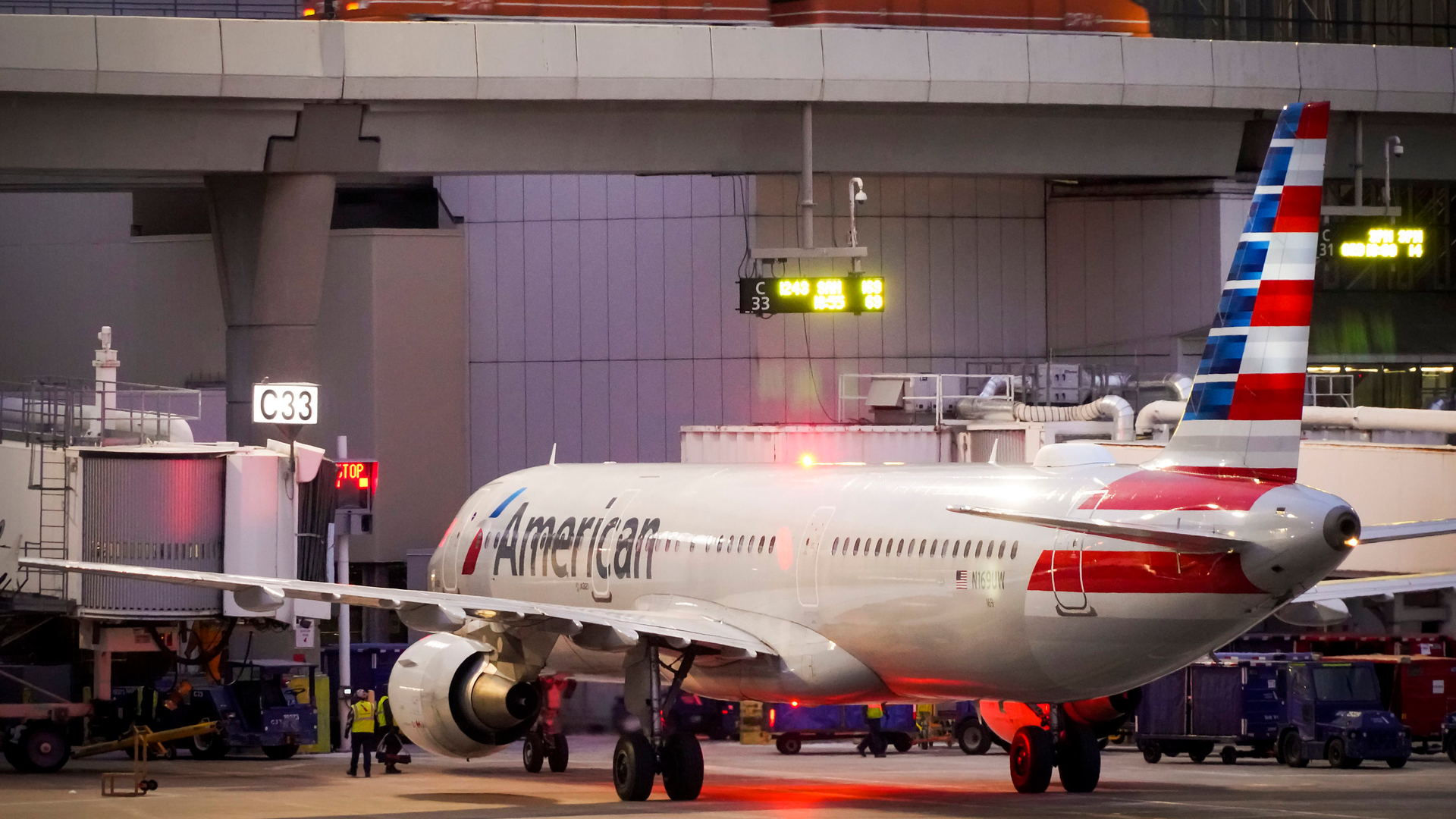 American Airlines planes are seen at the gates of Terminal C at the Skylink train passes overhead on at DFW Airport on Friday, Jan. 7, 2022.