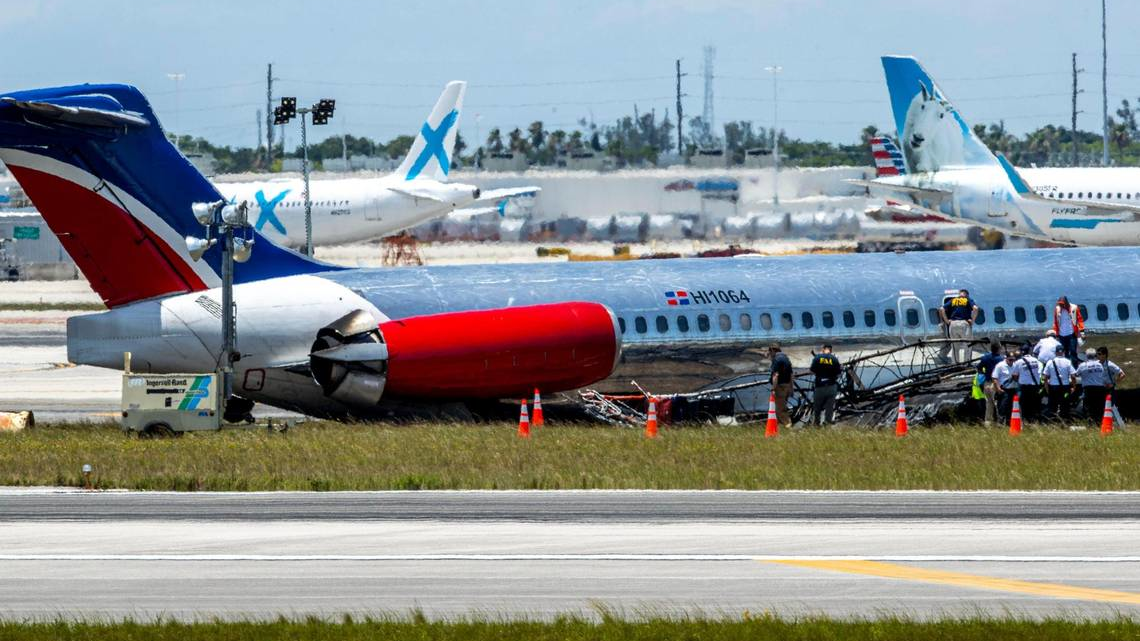 National Transportation Safety Board agents, Federal Aviation Administration agents and Miami-Dade Fire Rescue crews on Wednesday surround the RED Air plane that crash-landed on Tuesday at Miami International Airport.