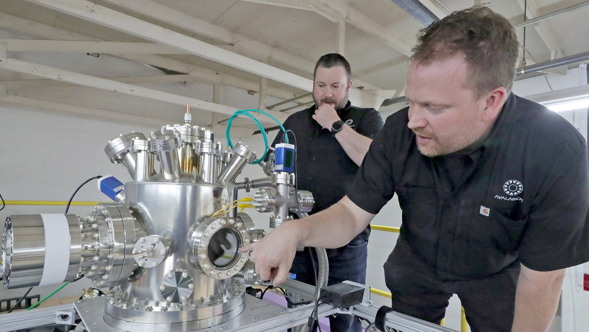 Avalanche Energy co-founders Robin Langtry, left, and Brian Riordan with their second prototype nuclear fusion reactor, on June 22, 2022. Avalanche Energy is a Seattle-based startup company that is in the process of developing a nuclear fusion reactor the size of a lunch box, called an 'Orbitron.'