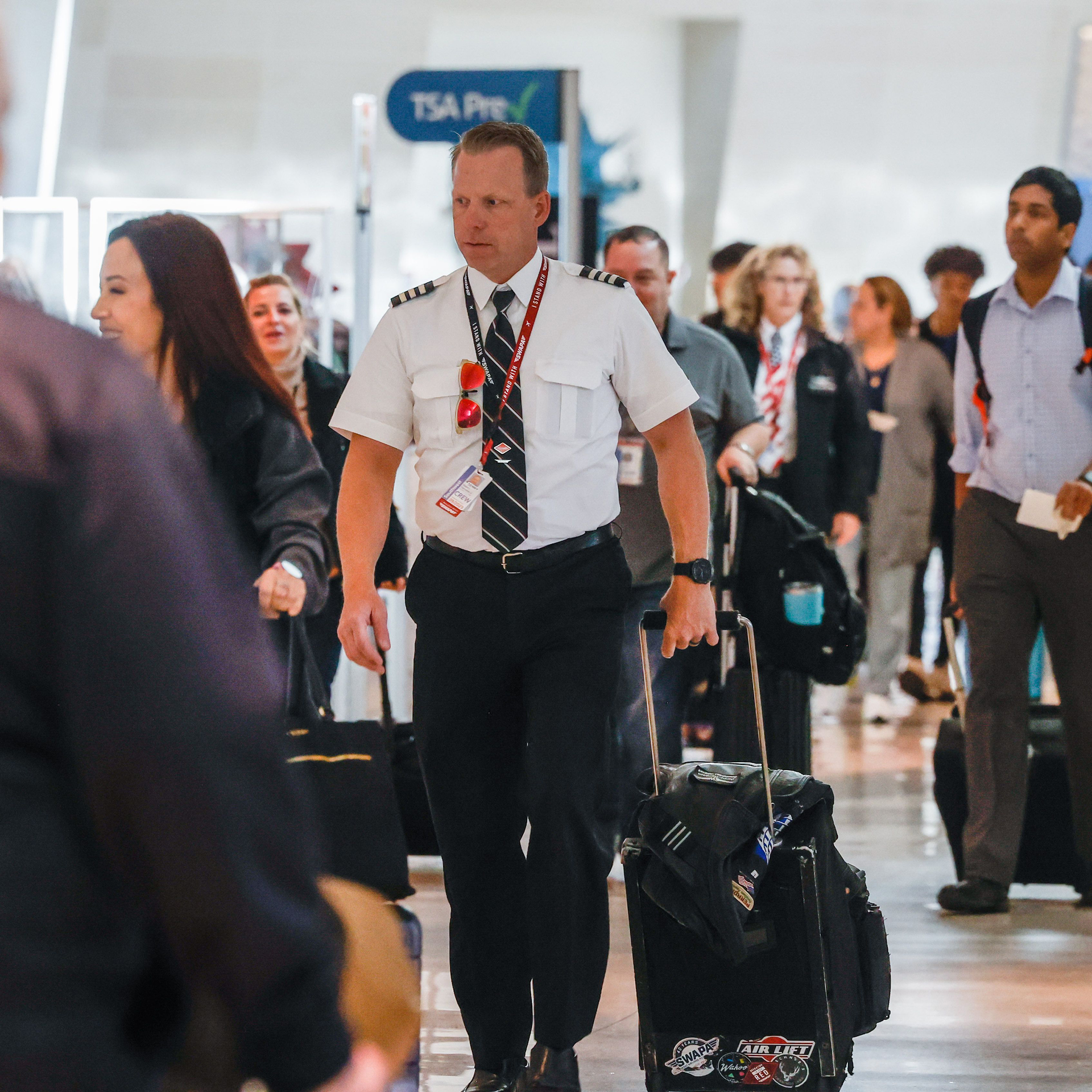 Southwest Airlines pilot Elden L. Hampton Jr. walks surrounded by travelers at the Dallas Love Field in Dallas on Thursday, Jan. 19, 2023.