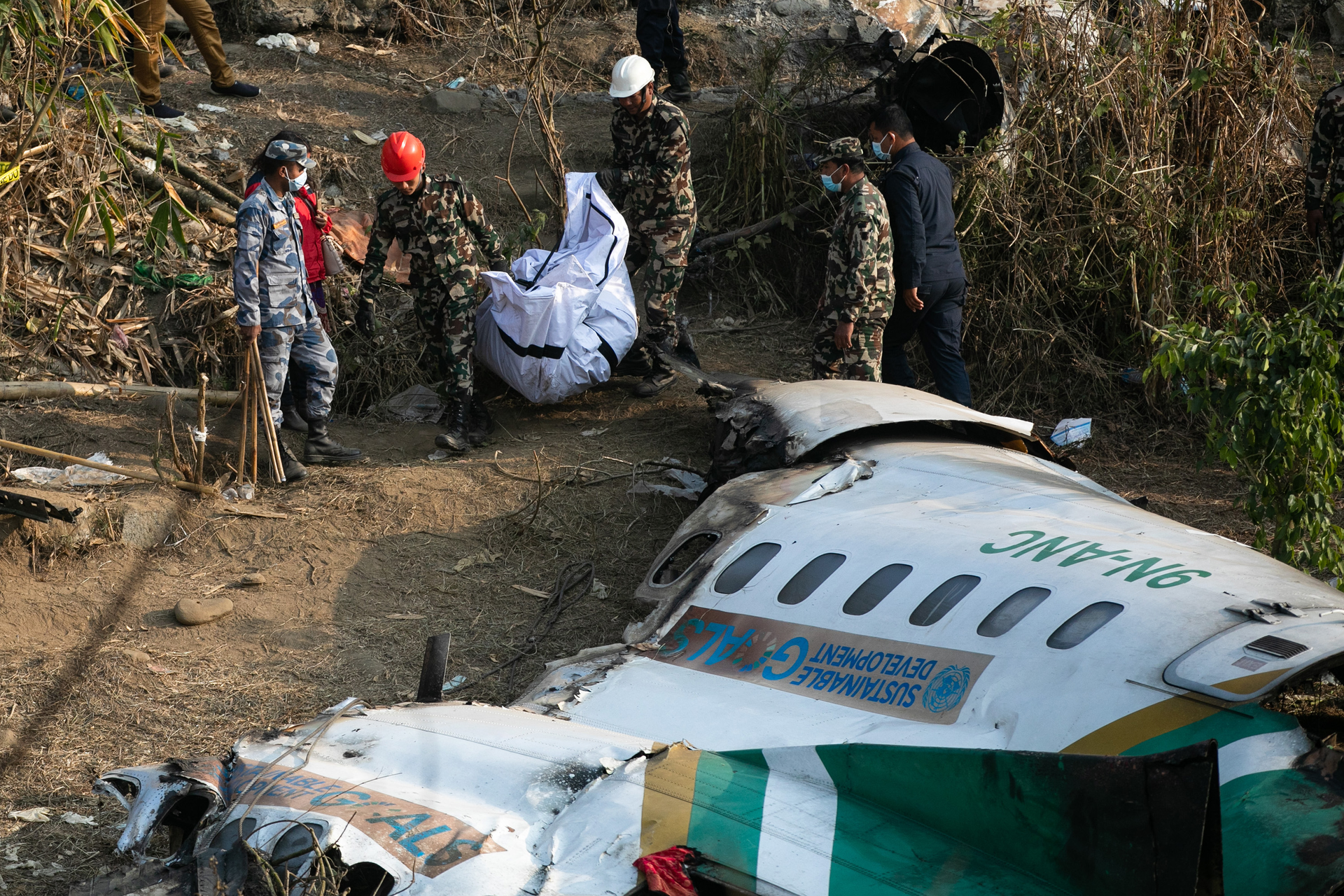 Nepal army, police and rescuers recover the body of a victim who died in a Yeti Airlines plane crash in Pokhara, Monday, Jan. 16, 2023. Nepal observed a day of mourning on Jan. 16 for the victims of the nation's deadliest aviation disaster in three decades, with 67 people confirmed killed in the plane crash.
