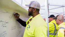 Eugene Walker, Heavy Equipment Operator for the Allegheny County Airport Authority, signs the final steel beam for the airport’s new terminal structure. Eugene Walker, Heavy Equipment Operator for the Allegheny County Airport Authority, signs the final steel beam for the airport’s new terminal structure.