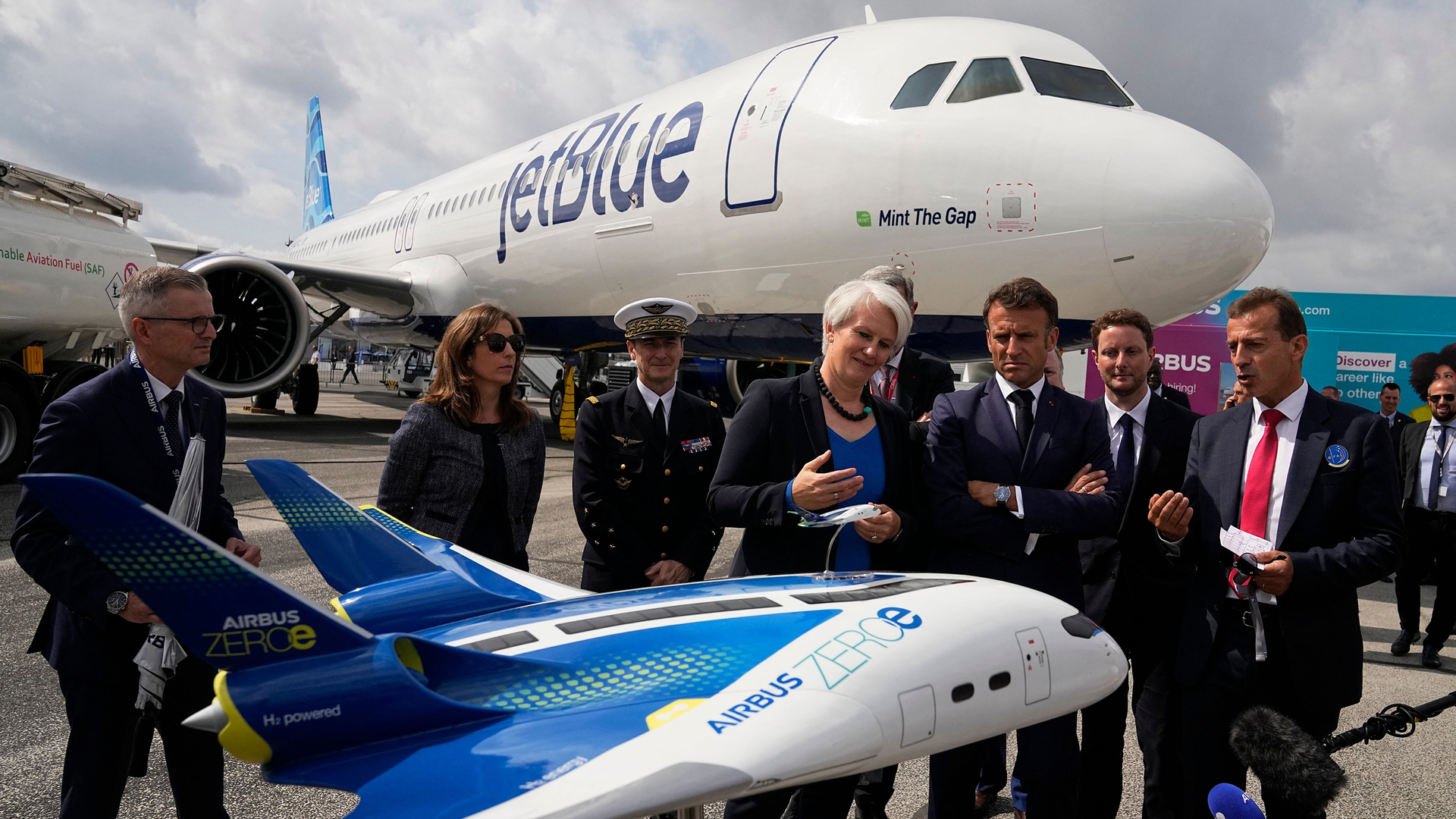 French President Emmanuel Macron, middle, and Airbus CEO Guillaume Faury, right, look at the concept hybrid-hydrogen aircraft Airbus Zero during the International Paris Air Show at the Paris-Le Bourget Airport on June 19, 2023.