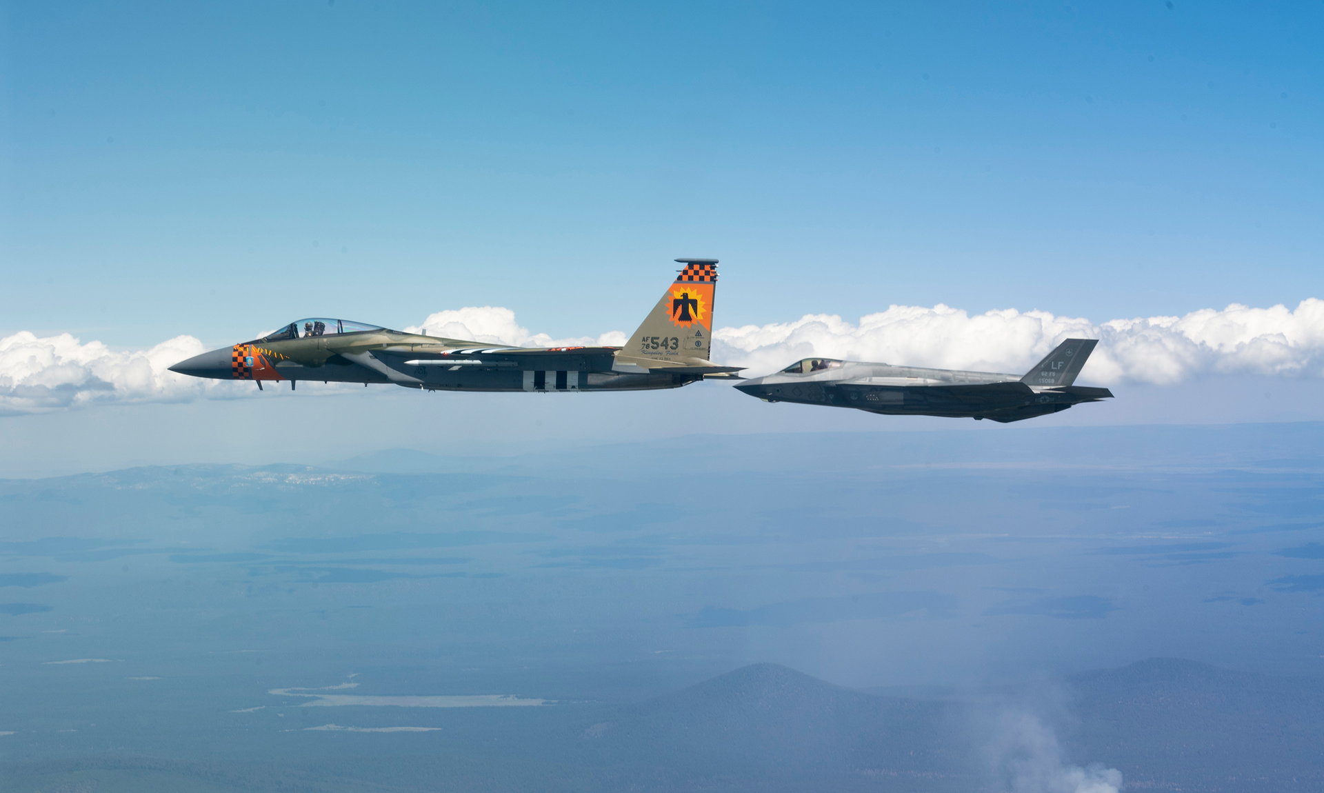 U.S. Air Force F-35A Lightning II assigned to Luke Air Force Base, Arizona, flies off the wing of an F-15C