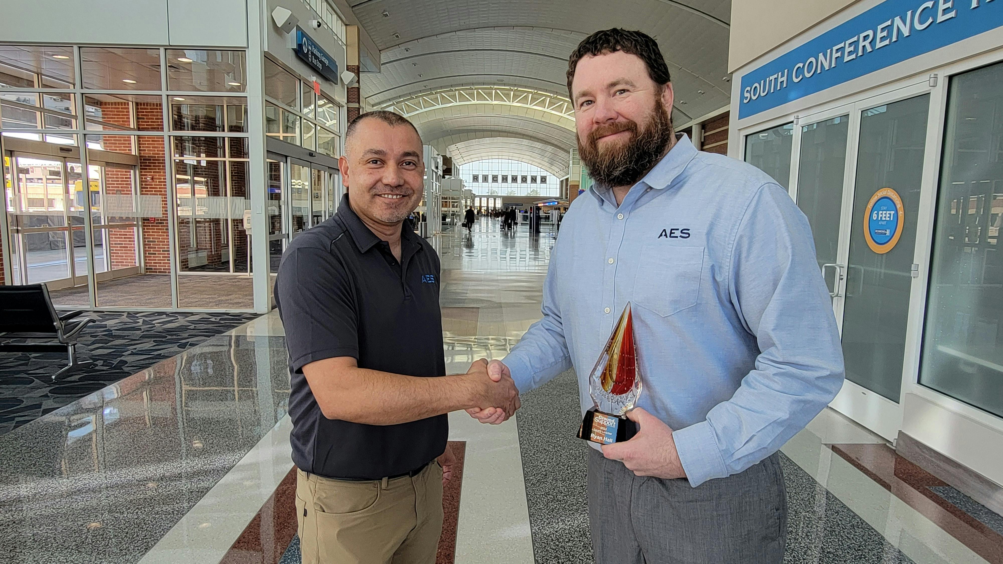 Jacob Gonzales (left), northeast regional manager at AES, congratulates Ryan Hall on winning the Team Leader of the Year.