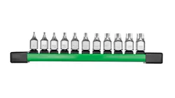 A line of 11 metal bit sockets sits on a green platform. A line of 11 metal bit sockets sits on a green platform.