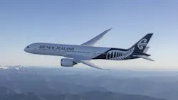 A white airplane with decorative designs on the tail and text on the side that reads: Air New Zealand A white airplane with decorative designs on the tail and text on the side that reads: Air New Zealand