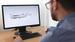 A man looking at a desktop computer that's displaying a 3D digital rendering of an airplane A man looking at a desktop computer that's displaying a 3D digital rendering of an airplane