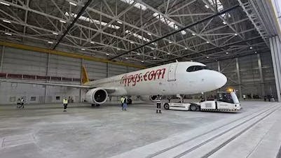 A white airplane sitting in an empty hangar