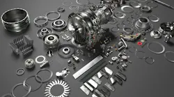 An array of metal airplane parts scattered on a dark gray surface An array of metal airplane parts scattered on a dark gray surface