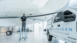 A man standing on a ladder near an airplane with a van parked next to him that has text on the side reading: RealClean Aircraft Detailing A man standing on a ladder near an airplane with a van parked next to him that has text on the side reading: RealClean Aircraft Detailing