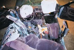 A view from the rear of the Mitsubishi Galant involved in the Dayton, OH incident, looking forward, shows crush damage on the driver's side. The victim being worked on had his feet crushed in the reat footwell area behind the driver's seat. The airbag diagnostic unit is on the driveshaft hump to the left of the passenger's seat. A view from the rear of the Mitsubishi Galant involved in the Dayton, OH incident, looking forward, shows crush damage on the driver's side. The victim being worked on had his feet crushed in the reat footwell area behind the driver's seat. The airbag diagnostic unit is on the driveshaft hump to the left of the passenger's seat.