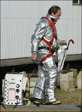 A Kennedy Space Center firefighter takes off his gear while awaiting word on the fate of the space shuttle Columbia, Saturday, Feb. 1, 2003, at the Kennedy Space Center in Cape Canaveral, Fla