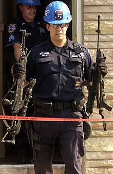 Cops retrieve weapons from a burned-out apartment yesterday.