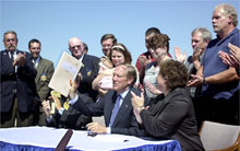 Governor George Pataki holds up the signed copy of Bradley's Law at the New York State office building Thursday in Utica. Bradley's Law is named for Bradley Golden, a Lairdsville volunteer firefighter trainee who was killed in a live fire exercise, Sept. 25, 2001. The law prohibits the use of live firefighters as victims during live burn exercises.