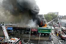 Fire crews battle a four-alarm blaze in Sunnyside, Queens, yesterday. The inferno gutted several businesses.