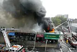 Fire crews battle a four-alarm blaze in Sunnyside, Queens, yesterday. The inferno gutted several businesses. Fire crews battle a four-alarm blaze in Sunnyside, Queens, yesterday. The inferno gutted several businesses.