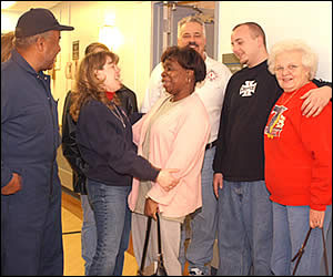 Dania Mahaffey and Carolyn Crockett, center, embrace after meeting on Thursday at Washington Hospital Center. Archie and Carolyn Crockett are the owners of the townhouse on Roseld Court where Dino sustained critical injuries almost one week ago. Other family members pictured include Dino's brother Wade, third from the right, and mother Mabel, far right.