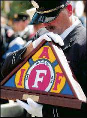 Firefighter Paul Nicholas prays during Saturday&rsquo;s International Association of Fire Fighters Fallen Fire Fighter Memorial Observance at Memorial Park. The monument has 1,686 names.