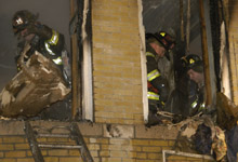 HEROES IN ACTION: Firefighters yesterday put out remnants of the fire, in which neighbors pitched in to pull the children to safety.