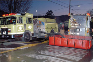 A mutual aid pumper from the Coudersport Volunteer Fire Department drafts from a portable tank as the Coudersport tanker sits ready to refill. This pumper supplied a pumper from Roulette and attack lines. Three tankers were used to supply portable-tank operations that augmented the hydrant supply from the municipal water system.