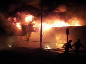 Firefighters relocate from the west side after Battalion Chief Gary Stevens called for a defensive attack.