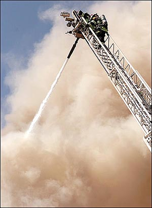 Virginia firefighters direct a high pressure foam spray onto a blazing department store from an aerial truck Thursday, April 14, 2005, in Virginia, Minn. The fire completely destroyed the business. (AP Photo/Mesabi Daily News, Mark Sauer)