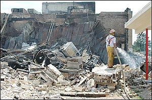 Hope firefighter Todd Martin, right, sprays water on the rubble of the destroyed portion of Hope High School, Sunday, April 17, 2005, in Hope, Ark.(AP Photo/Texarkana Gazette, Jim Williamson)