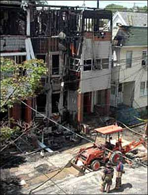 HOT WORK: Firefighters battle a blaze that took five hours to control. The fire destroyed two homes (above) and damaged two others.