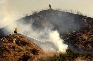U.S. Forest Service firefighters mop up the top of a hill after a fire burned above the Chapman Heights area of Yucaipa, Calif., Thursday, July 14, 2005. Dry grass fueled a fire that rapidly burned across more than 150 acres Thursday in this San Bernardino County hillside community, but no homes or structures were lost, officials said.