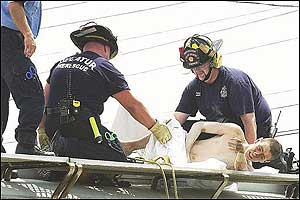Decatur, Ala., firefighters Doug Belletete, left, and Jason Jones, cover Mark Cody White, 17, of Hartselle, Ala., Monday, July 18, 2005, as he was rescued after apparently spending nearly three days in a hot railroad tanker car used to store processed fertilizer. White was doused with a water hose to remove any chemicals, then wrapped in a sheet and taken to a hospital, where he was treated and released, officials said.