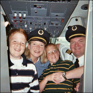 Selena and Glen Schmidt and their sons Trevin and Justin during a visit to Glen&rsquo;s &ldquo;workplace&rdquo; in an Air Train Airways cockpit.