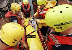 Rural Metro firefighters prepare to evacuate Joseph Kogel, 18, from the mobile home where he lives with his family Aug. 7, 2005, in Tucson, Ariz. Storms dumped up to 4 inches of rain Tuesday, Aug. 23, 2005, across southern Arizona, flooding washes and waterways and forcing evacuations of some 46 people in the Tucson area. Rural Metro firefighters prepare to evacuate Joseph Kogel, 18, from the mobile home where he lives with his family Aug. 7, 2005, in Tucson, Ariz. Storms dumped up to 4 inches of rain Tuesday, Aug. 23, 2005, across southern Arizona, flooding washes and waterways and forcing evacuations of some 46 people in the Tucson area.