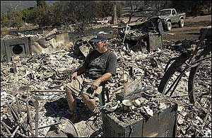 Frank Ketchum, 66, sits in a chair in what used to be his home in Manton, Calif., about 45 miles west of Redding, Sunday morning, Aug. 28, 2005, after a blaze there injured three people and destroyed 30 structures. California Department of Forestry and Fire Protection spokeswoman Sandra Hayes said firefighters believe the blaze was sparked by a vehicle in a dry, grassy area but they could not pinpoint the exact cause. The blaze which began Friday burned 1,830 acres and 30 structures is 60 percent contained with full containment expected Tuesday morning.