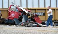 A New Summerfield firefighter looks at the twisted wreckage of his department's water tanker after the vehicle struck a Union Pacific train Saturday afternoon.